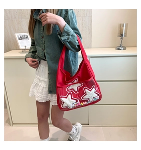 Détail du cabas rouge en nylon avec patchs étoiles et pompons colorés en poche transparente