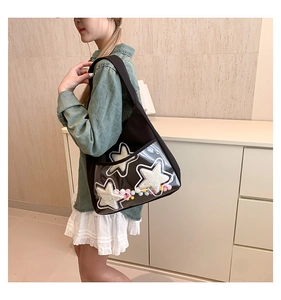 Détail d'un cabas noir avec poche PVC transparente contenant des pompons colorés