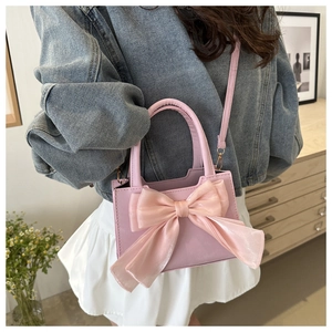 Vista dettagliata della borsa rosa in PU con grande fiocco in organza e tracolla