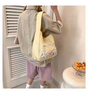 Détail du cabas en toile jaune avec poche étoile en PVC transparent et décor perlé