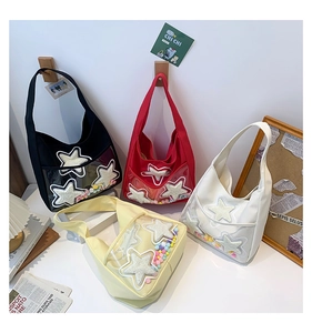 Gros plan de sacs bandoulière en toile en quatre couleurs avec détail d'étoile en PVC