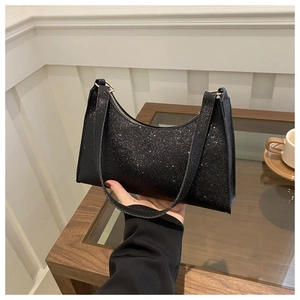 Détail du sac baguette à paillettes noires avec texture scintillante et zip doré