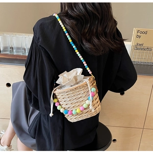 Détail du sac seau en paille tissé à la main avec chaîne perlée colorée et doublure