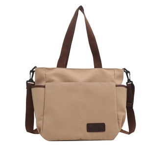 Beige canvas tote bag with adjustable brown straps and side pockets on white background