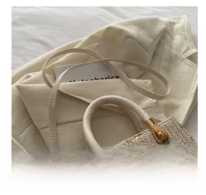 Detail showing beige woven fabric with floral embroidery and golden metal buckle hardware