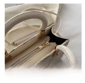 Close-up of smooth gold metal zipper and internal storage compartments of straw bag
