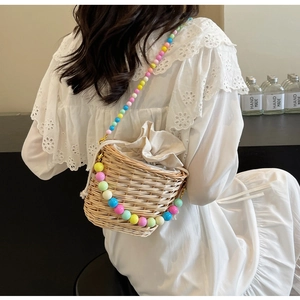 Détail du sac seau en rotin tissé main avec perles colorées et bandoulière perle