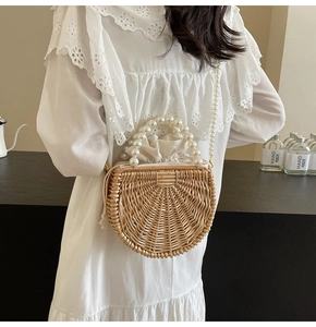 Detailed view of the woven rattan bag with pearl handle and canvas drawstring lining