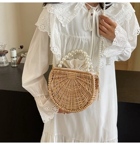Detail of semi-circular rattan bag with pearl handles and drawstring inner bag