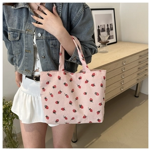 Pink corduroy tote bag with strawberry prints shown in a cozy minimalist home interior