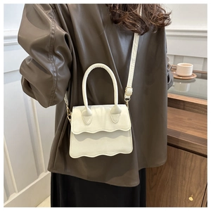 Detail of white wave-edge mini PU leather handbag with adjustable shoulder strap