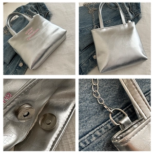 Dettaglio della borsa tote argento con ricamo e pratica chiusura magnetica a scatto.