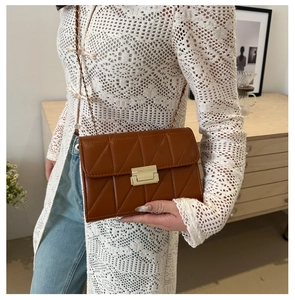 Détail du sac à bandoulière matelassé marron avec fermoir doré et bandoulière chaîne