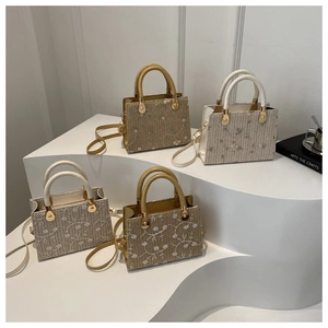 Straw tote bag with floral lace embroidery and leather handles on white display stand