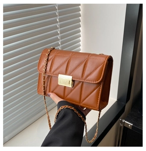 Détail d'un sac bandoulière matelassé marron caramel avec fermoir doré et bandoulière
