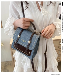 Detail of retro denim and brown leather crossbody bag with vintage metallic buckle