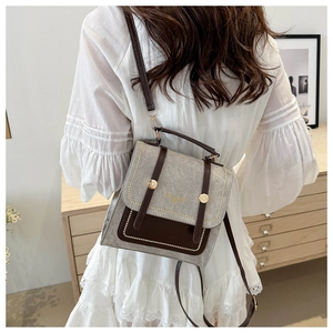 Close-up of contrast retro crossbody bag featuring gold hardware and stitched leather straps