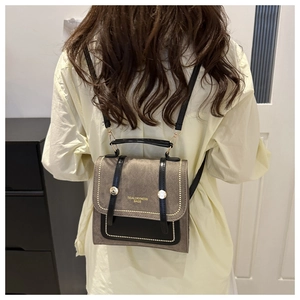 Model wearing a retro contrast-color mini backpack with rivets and metal buckle