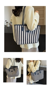 Close-up of navy and cream striped canvas tote bag with black leather shoulder straps