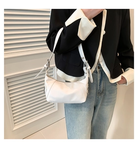 Chic white leather underarm bag styled with a stylish casual jacket and denim jeans