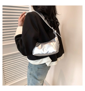 Makroansicht der silbernen sichelförmigen Schultertasche mit eleganter Textur und Schnalle