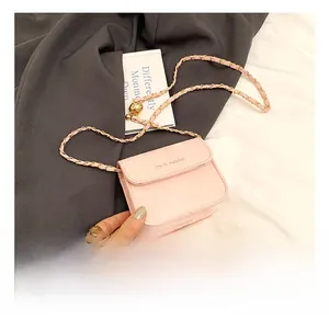 Close-up of pink mini crossbody bag with gold chain and rich rabbit brand logo