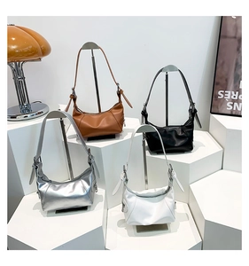 Detailansicht von sichelförmigen Hobo-Taschen in Braun, Schwarz, Silber und Weiß
