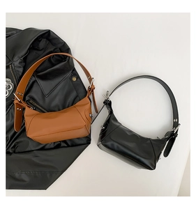 Top view of two minimalist baguette bags in brown and black with wide silver grommet straps