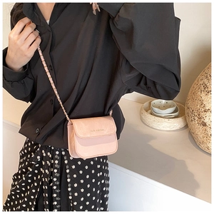 Close-up of mini pink rich rabbit crossbody bag with elegant leather chain strap detail