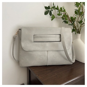 Close-up of light gray PU leather bag with lychee texture and rectangular cutout handle