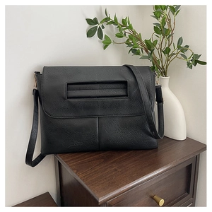 Close-up of black lychee grain PU leather crossbody bag with a decorative handle on the front