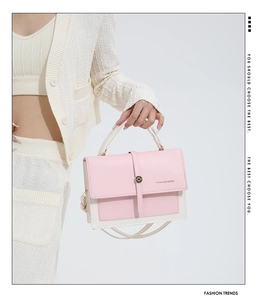 Detail of pink and white PU leather handbag with metal buckle and fashion logo text