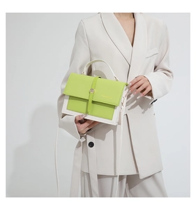 Detail of candy-colored crossbody bag with neon green panel and gold metal clasp