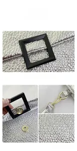 Macro view of silver textured leather clutch with magnetic buckle and golden strap detail