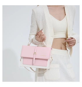 Detail of pink and white contrast leather handbag with metal buckle and shoulder strap