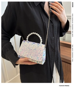 Detail of sequined mini square bag featuring faux pearl handle and gold chain strap