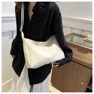 Detail shot of white soft leather tote bag showing fine texture and neat stitching