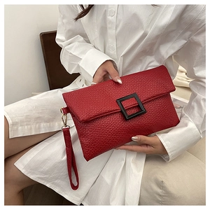 Red pebbled leather envelope clutch with decorative black buckle and wristlet detail