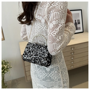 Chic silver sequin handbag with pearl handle and gold chain worn with a white lace dress