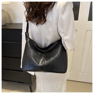 Minimalist black lychee pattern PU leather tote bag shown from a back-shoulder view