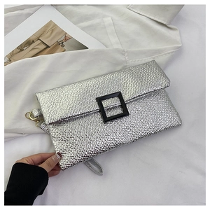 Detail of silver crinkled envelope clutch with black square buckle and wrist strap
