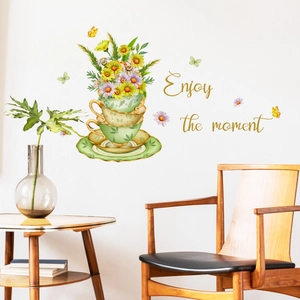 Detail of floral wall sticker featuring green teacups and Enjoy the moment gold text