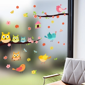 Cartoon owl and bird stickers on a tree branch for window and glass decoration