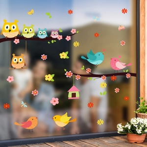 Detail of colorful owls and birds static stickers on a glass window for home decoration