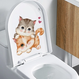 Detail of cute cartoon cat wall sticker applied on white toilet lid in modern bathroom