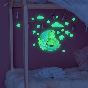 Glow-in-the-dark wall stickers featuring a cartoon moon, giraffe, and stars in a dark room