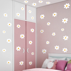 White daisy wall decals applied to pink and white furniture in a cozy bedroom setting