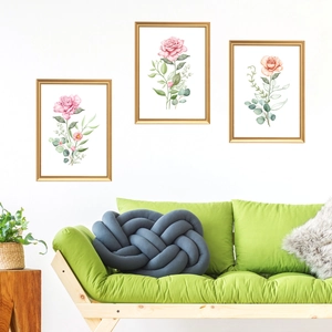 Detailed view of three watercolor floral art pieces with elegant golden metal frames
