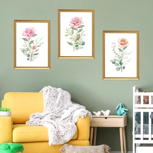 Three-piece floral wall art set with golden frames over a green sofa in a living room