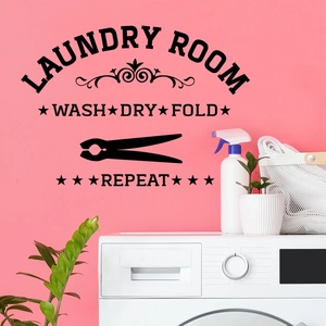 Detail der schwarzen Laundry Room Wandaufkleber mit Wash Dry Fold Text auf rosa Wand